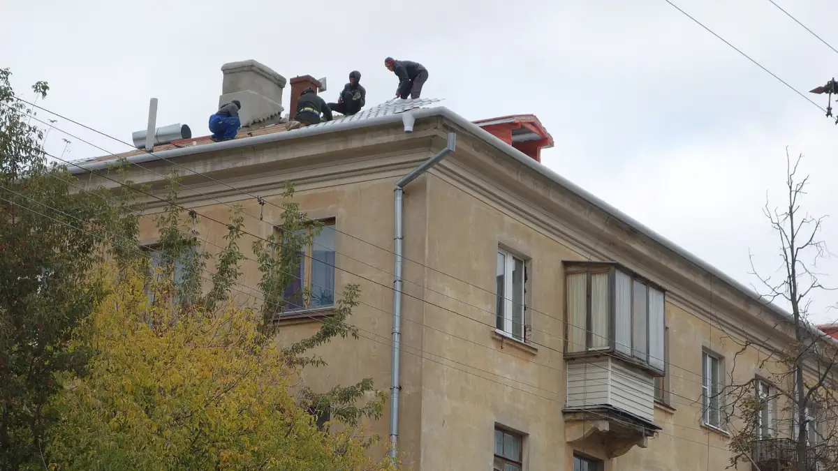 Cuadrilla de aplicadores trabajando sobre la cubierta de un edificio